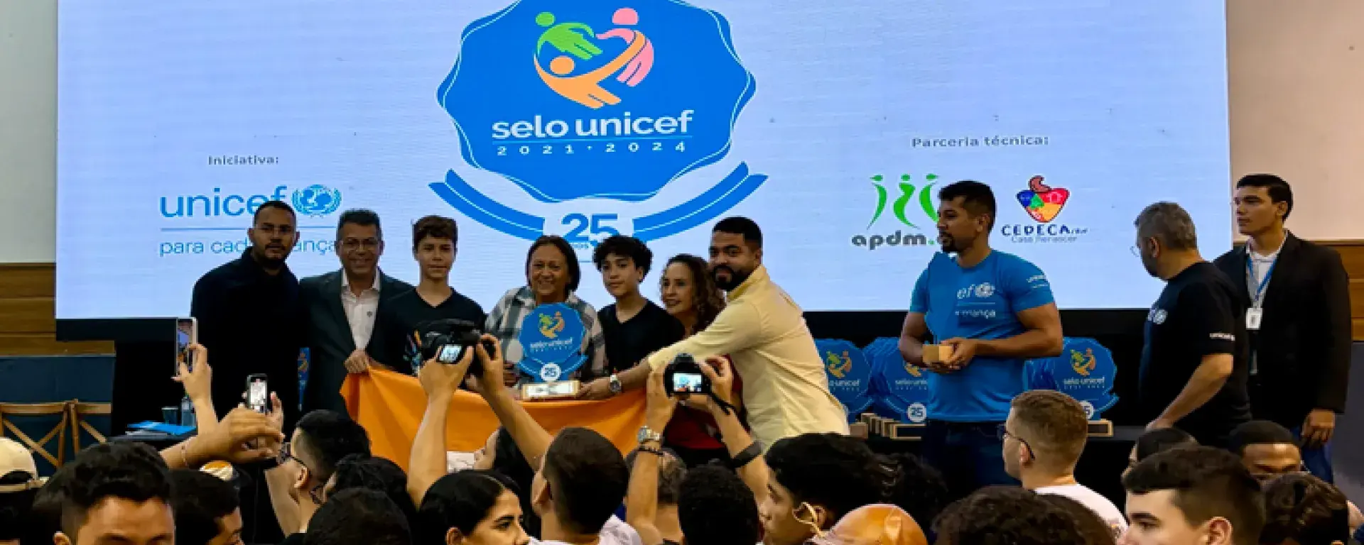 Municípios do Rio Grande do Norte celebram a certificação do Selo UNICEF. No palco, a governadora Fátima Bezerra entrega o troféu a representantes municipais