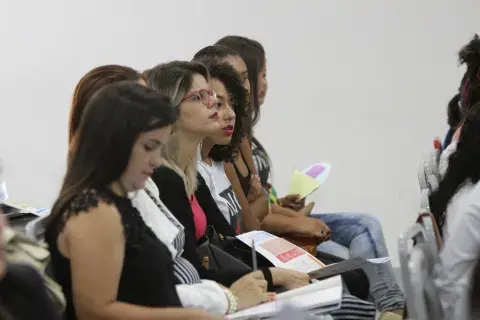 Concentrados, os participantes anotam dicas e ferramentas para monitorar os alunos