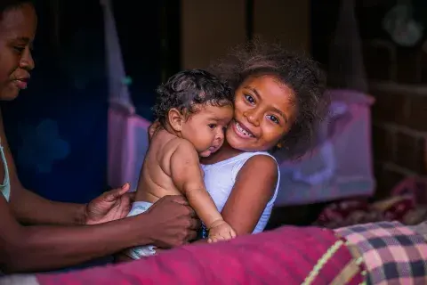 Criança abraça um bebê ©UNICEF/BRZ/RAONI LIBORIO